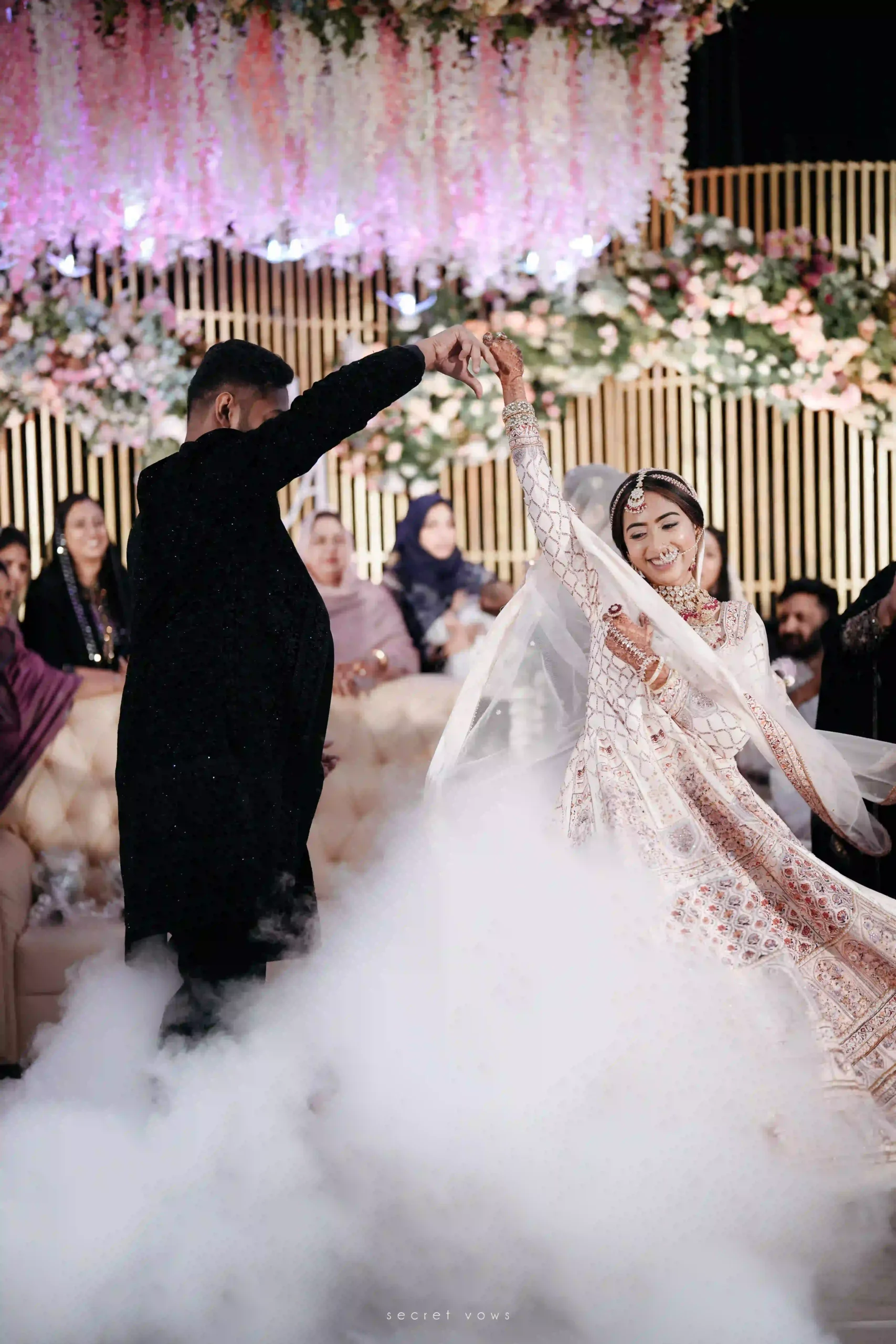 Smiling couple dancing together at their wedding on stage