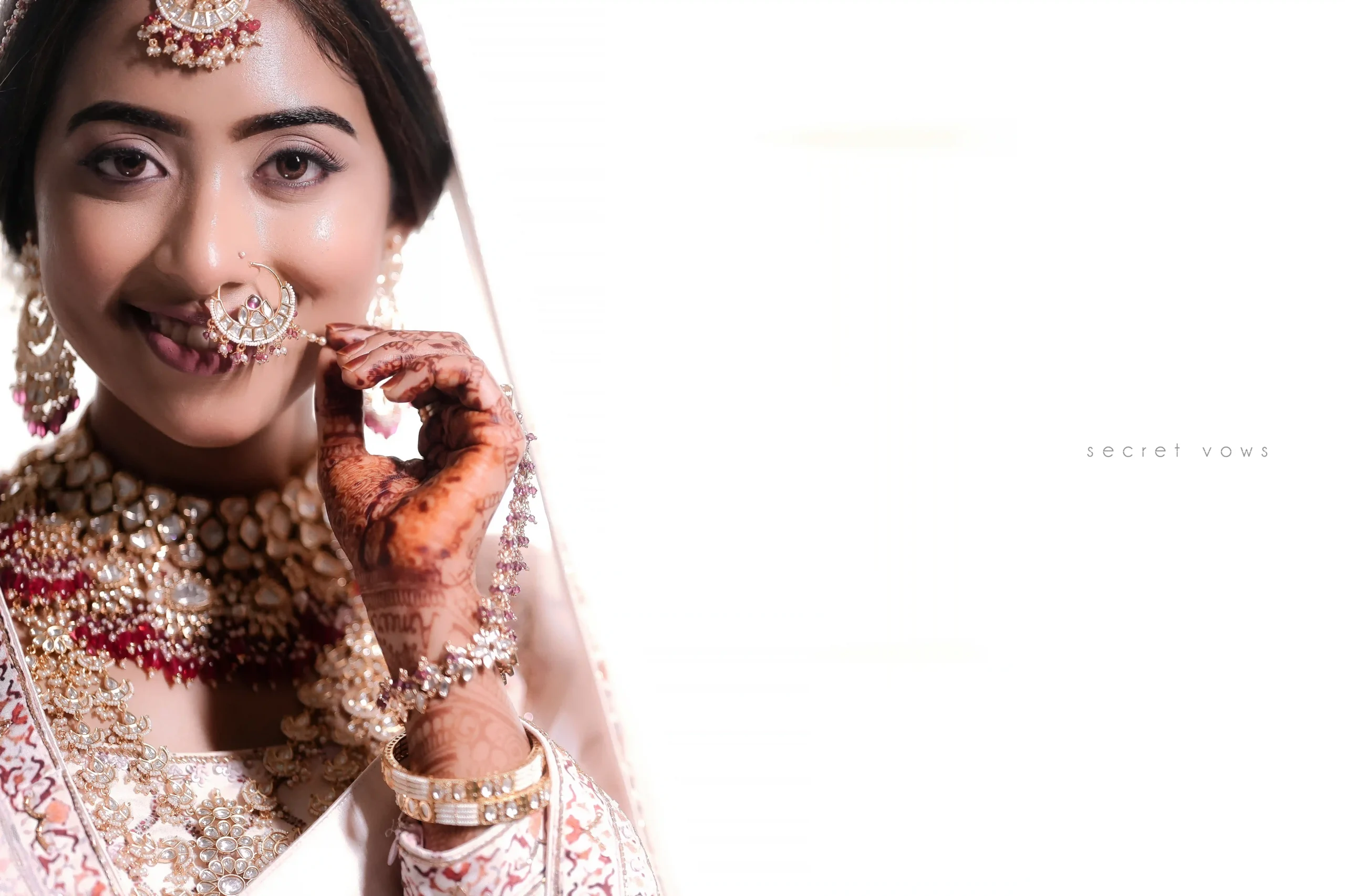 Elegant bridal portrait with bride touching her earrings in white outfit