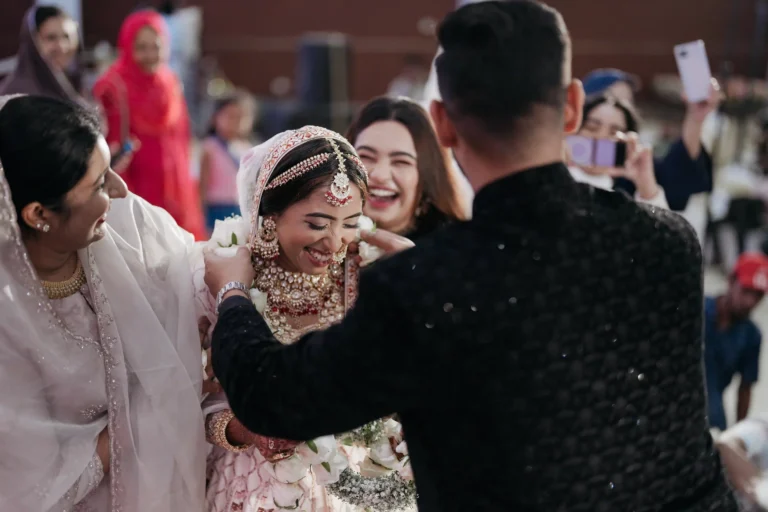 Bride and groom smiling as they exchange garlands on wedding stage