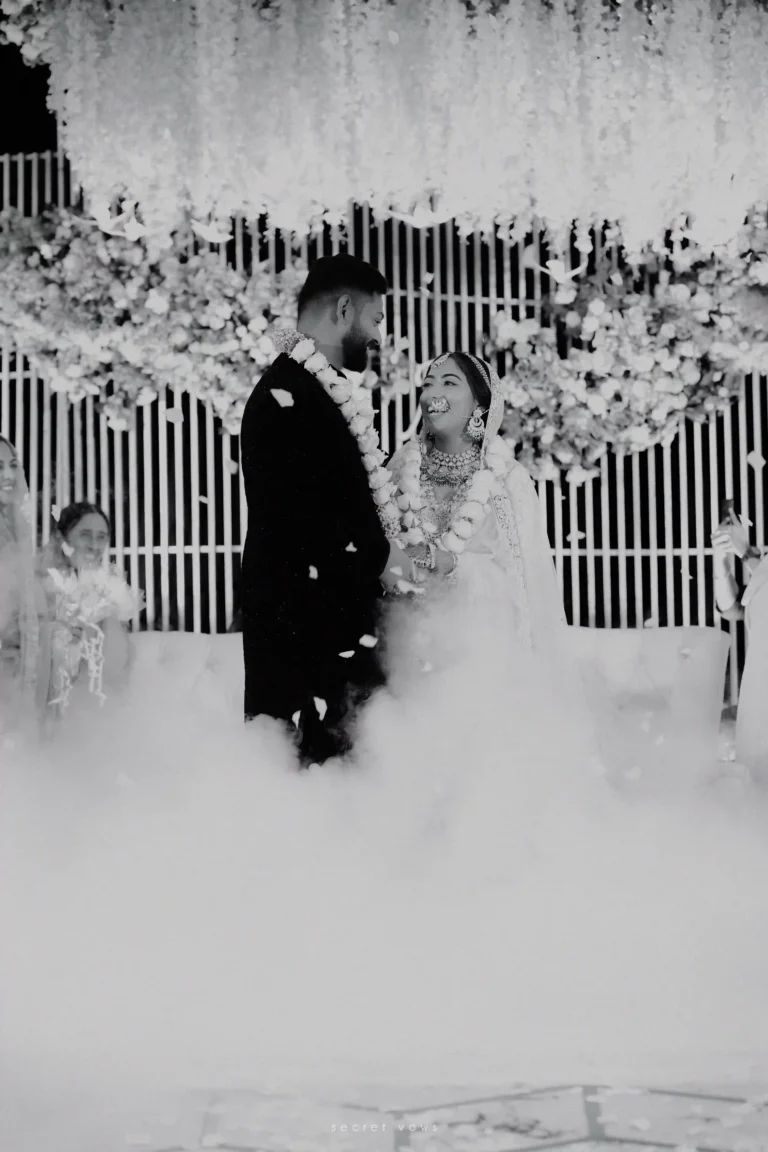 Bride and groom smiling together on beautifully decorated wedding stage