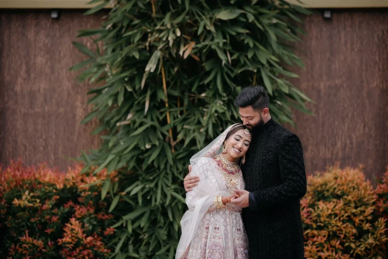 Bride resting on groom’s shoulder during outdoor wedding portrait