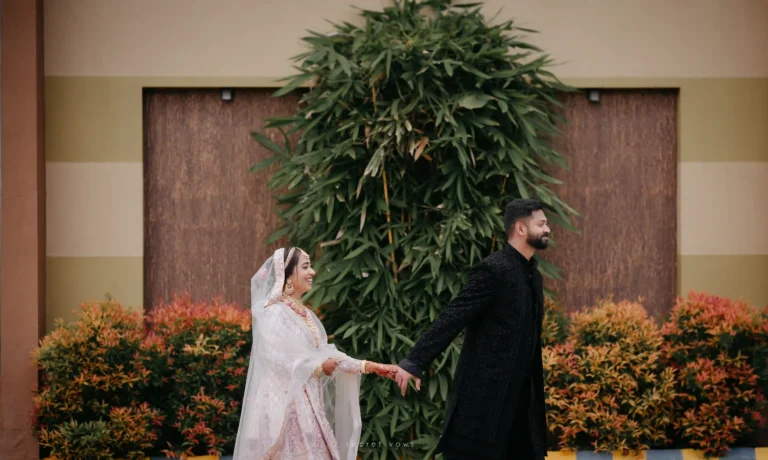 Couple walking together in lush greenery during post-wedding shoot