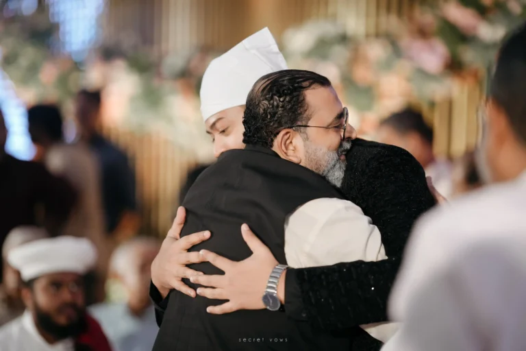 Groom and bride’s father sharing a warm traditional hug on wedding day