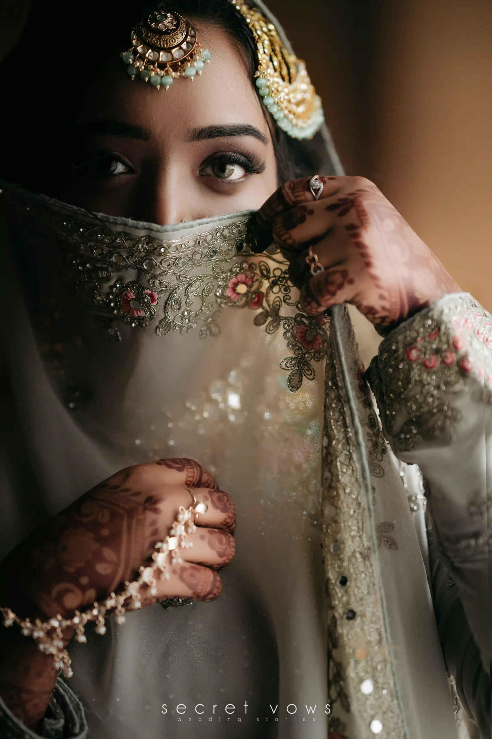 Close-up bridal portrait with intricate veil and henna, captured by Secret Vows Wedding Photography in Kerala